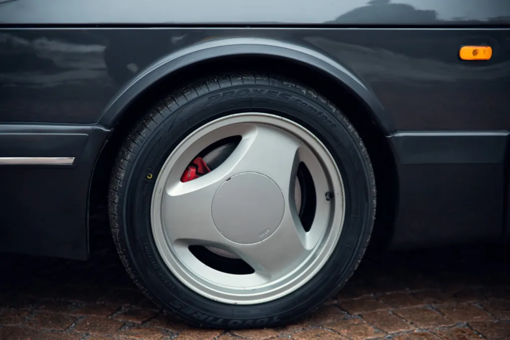 Black car with silver rim and performance tire