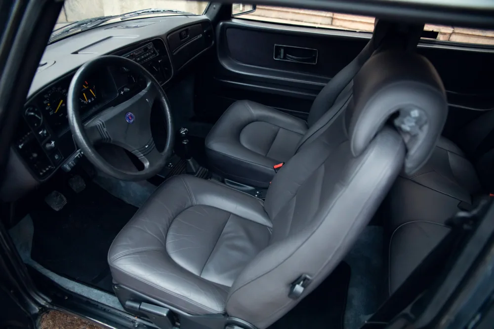 Gray leather interior of modern vehicle with dashboard view.