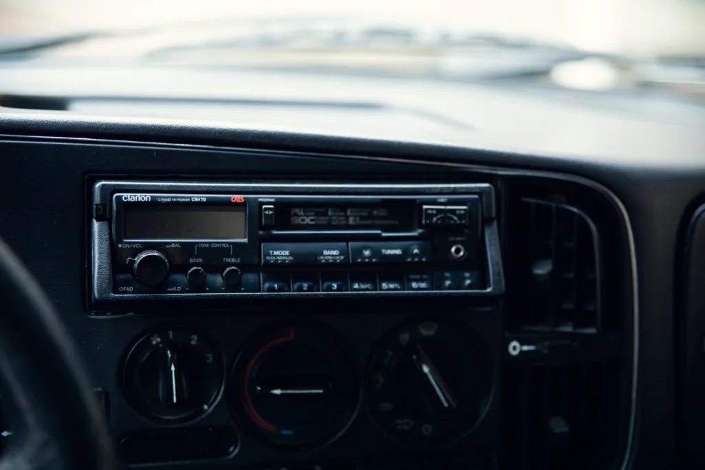 Vintage Clarion car stereo and dashboard.