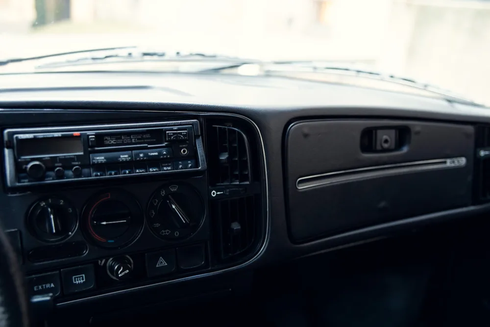 Vintage car dashboard with radio and climate controls.