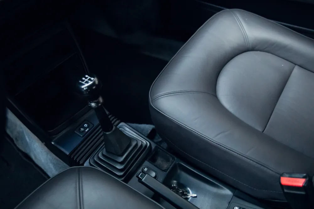Car interior with manual transmission and leather seats.