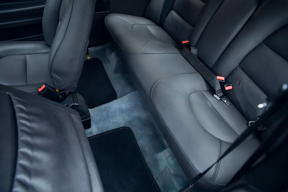 Black leather car rear seats with seat belts