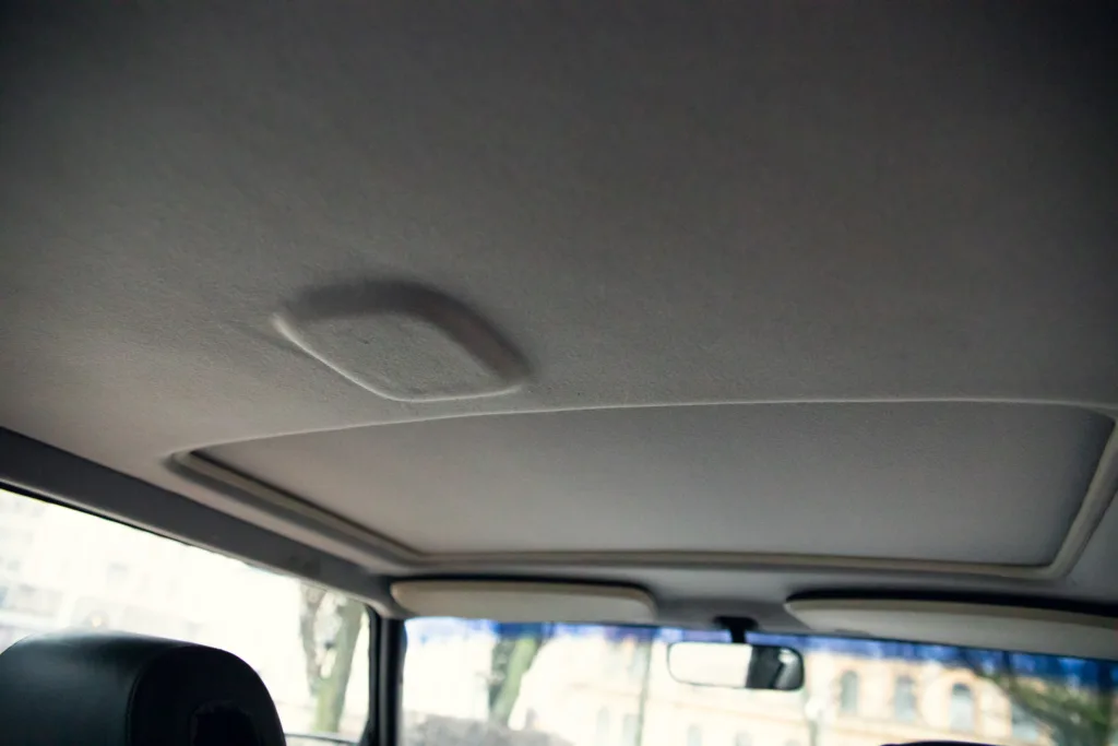 Car ceiling with noticeable dent.