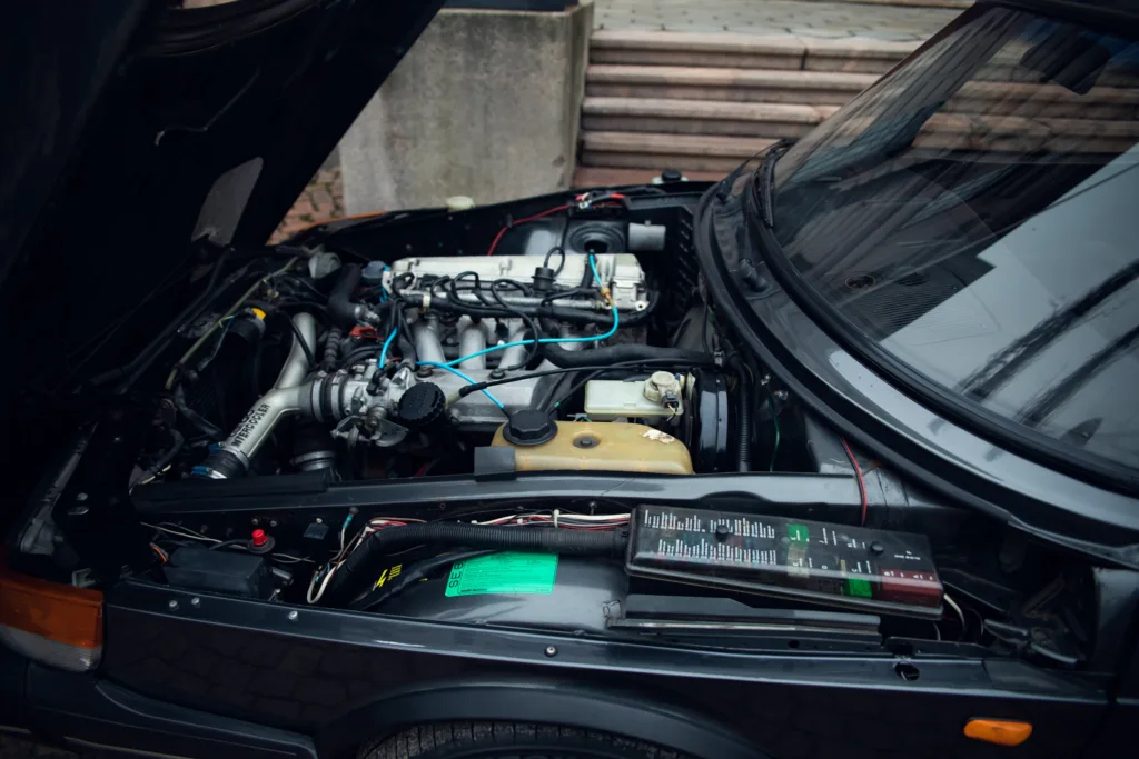 Open hood revealing car engine and components.