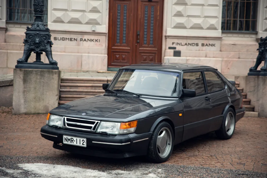 Vintage black sedan parked outside elegant building.