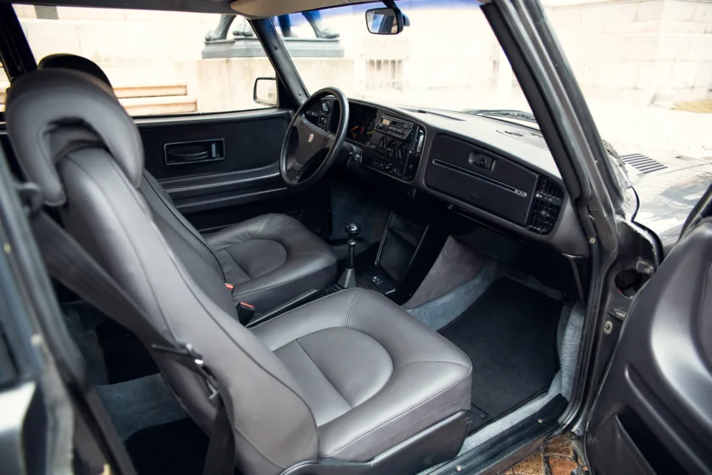 Vintage car interior, leather seats, manual transmission.