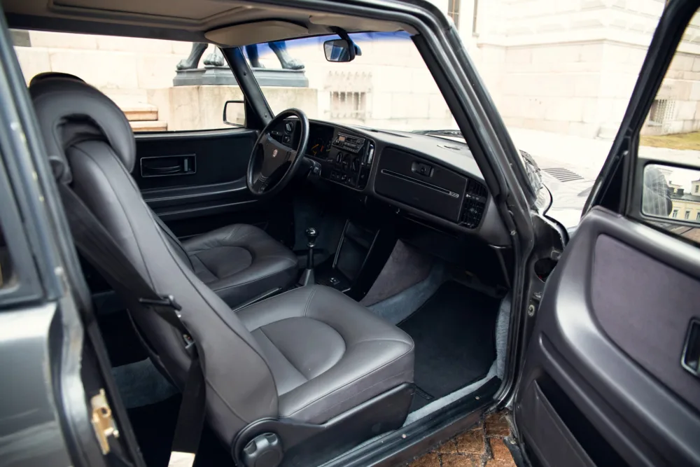 Black vintage car interior with leather seats.