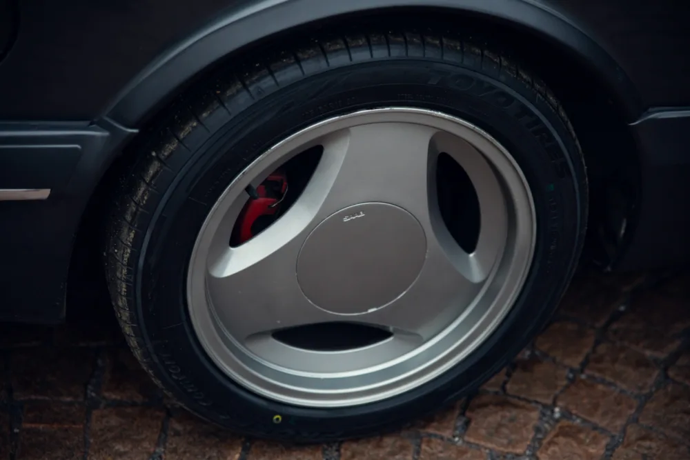 Car wheel with red brake caliper and tire.