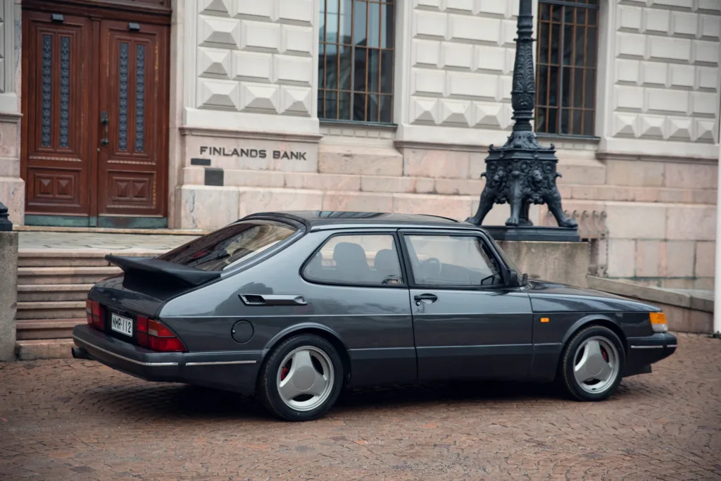Vintage car parked outside historical building.