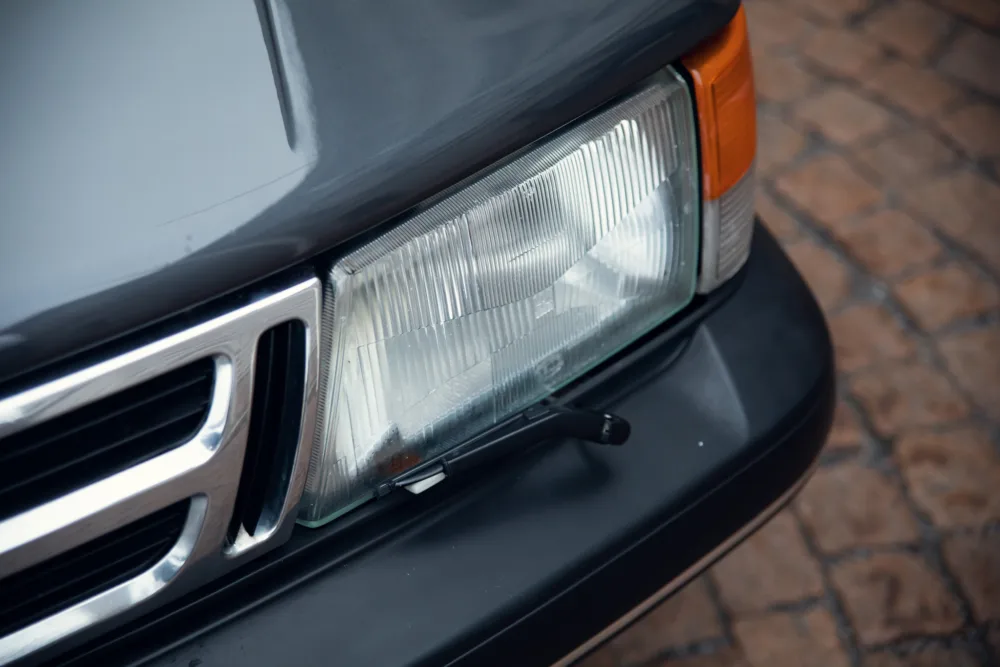 Close-up of vehicle headlight and grille.