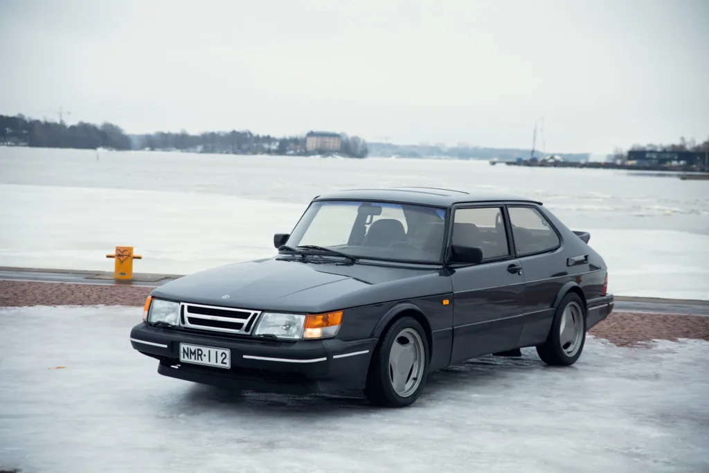 Vintage car on icy lakeside road.