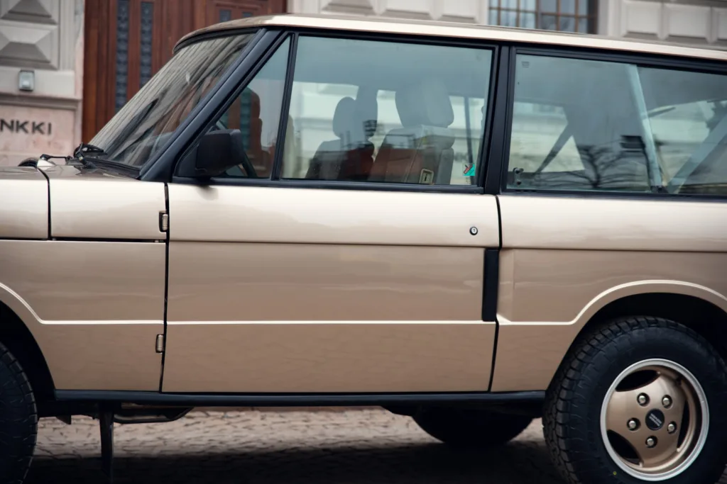 Vintage beige SUV parked on street.