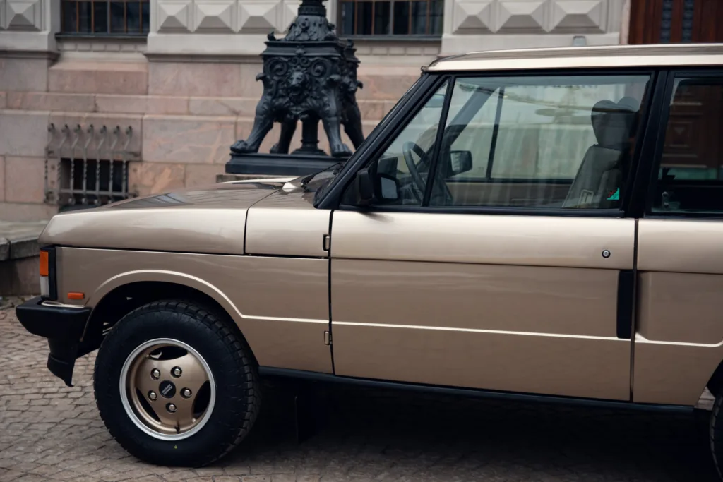 Vintage car parked near historical building.