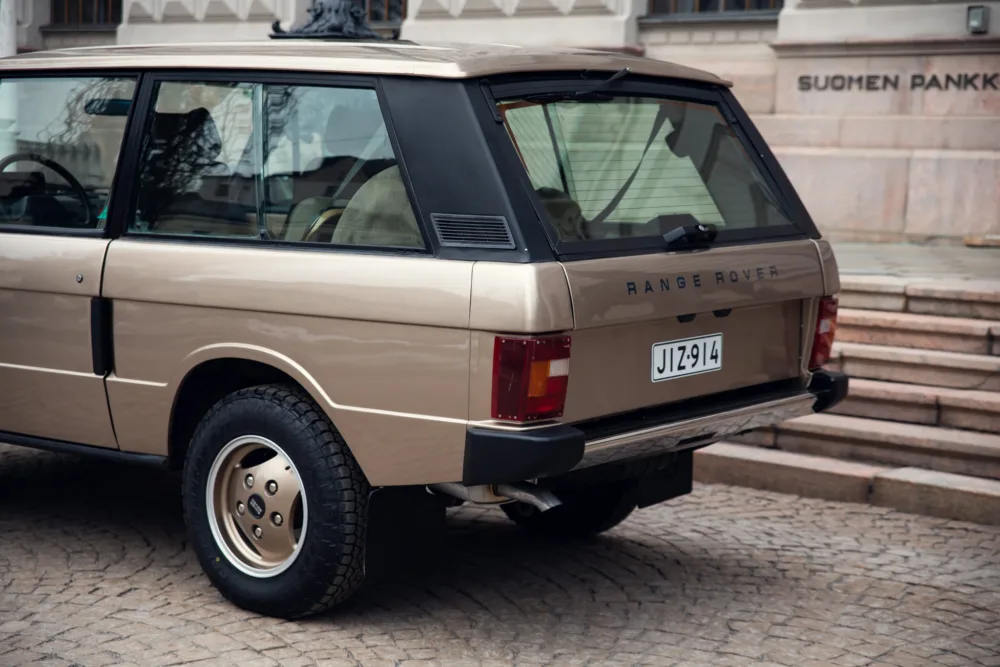 Classic beige Range Rover parked near steps.