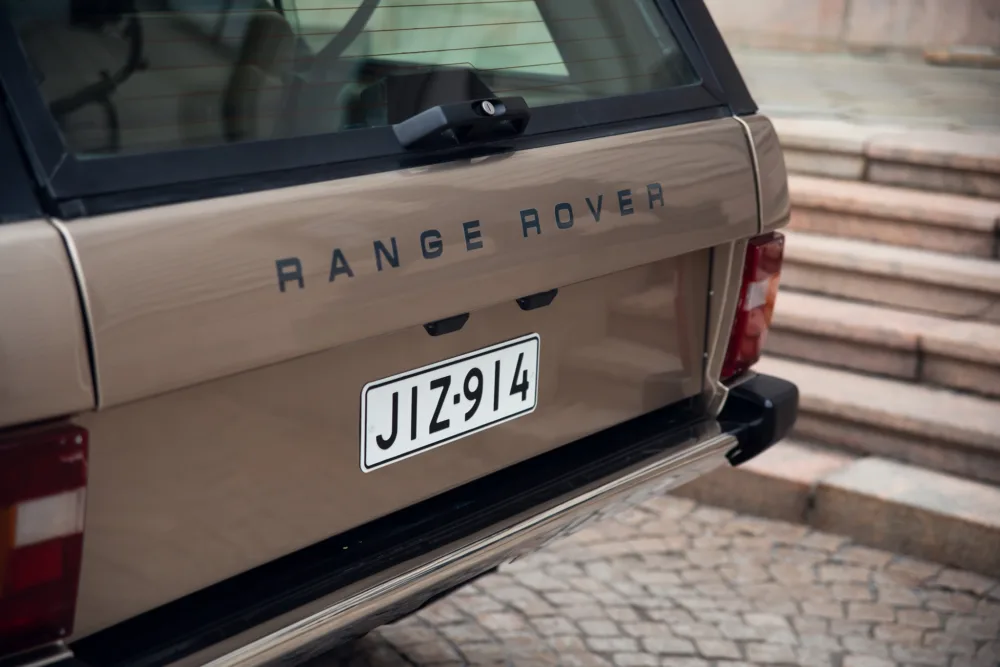 Beige Range Rover rear view with license plate.