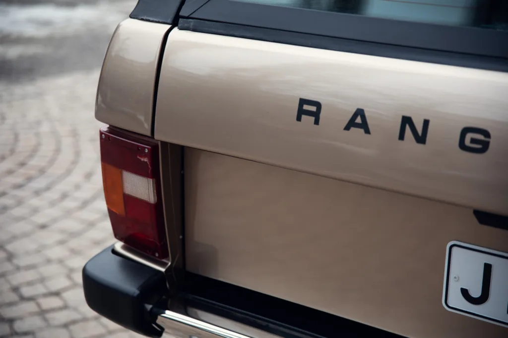 Beige SUV rear badge and taillight detail.