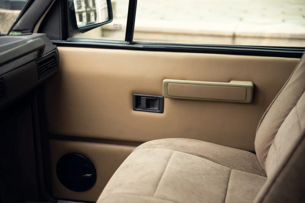 Vintage car interior, beige door and fabric seat.