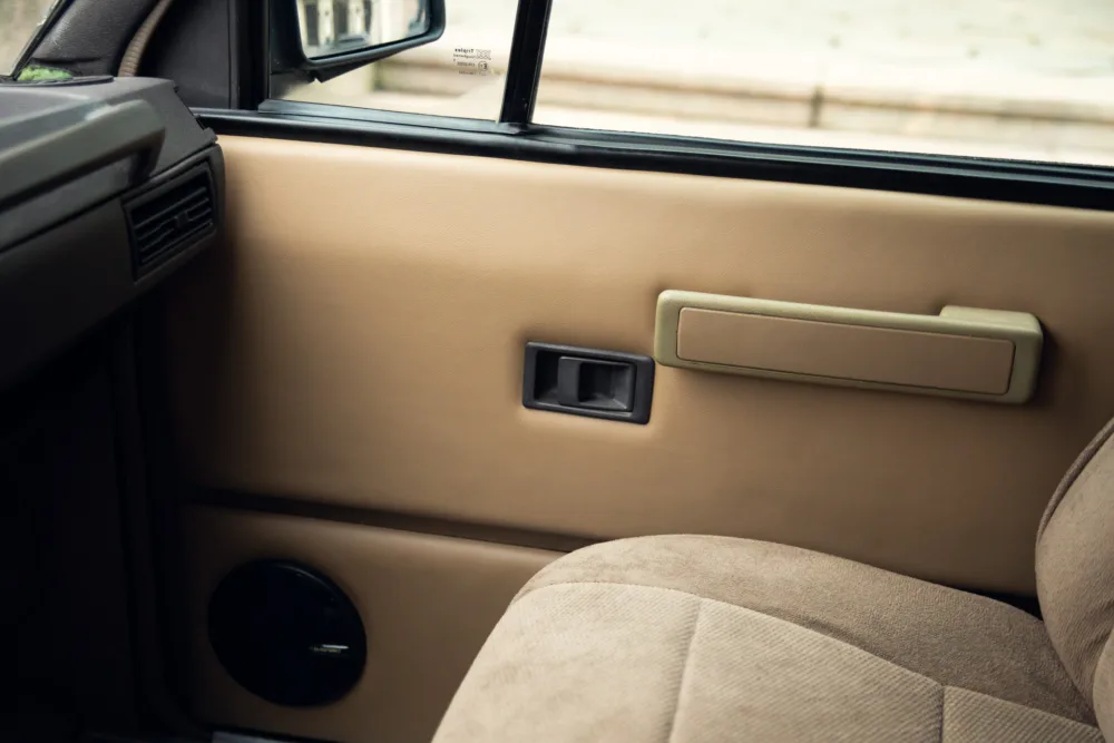 Car door interior with window controls and handle.