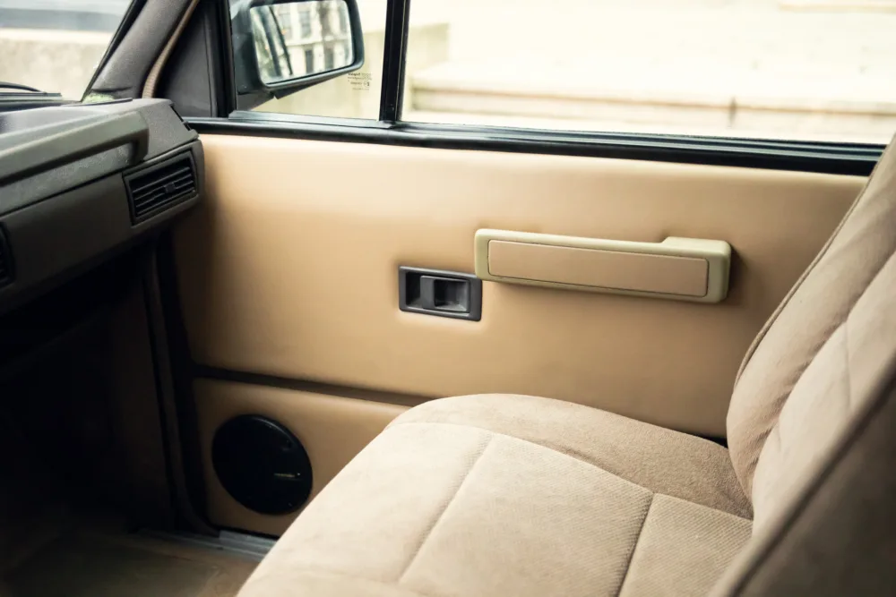 Car door interior with handle and window controls.