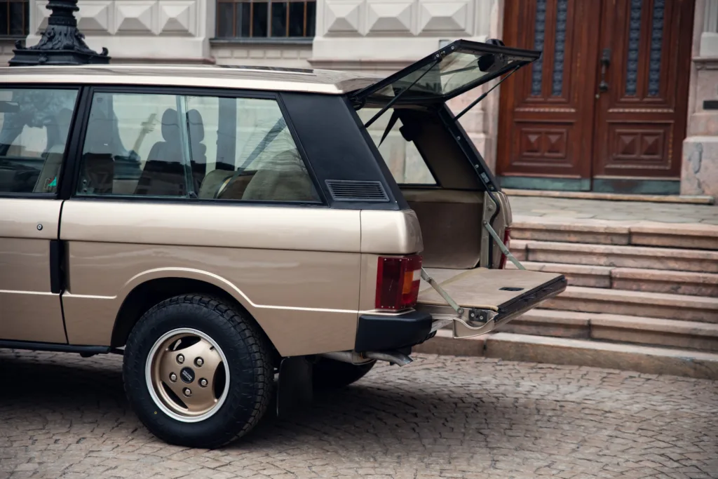 Vintage car with open tailgate in urban setting.