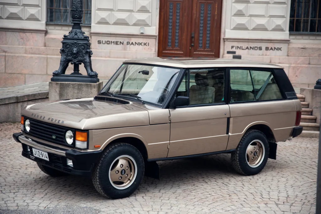 Vintage Range Rover parked near building.