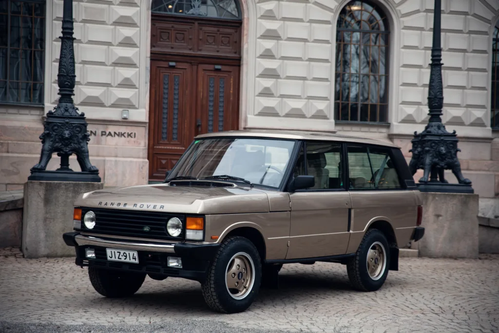 Vintage Range Rover parked in urban setting.