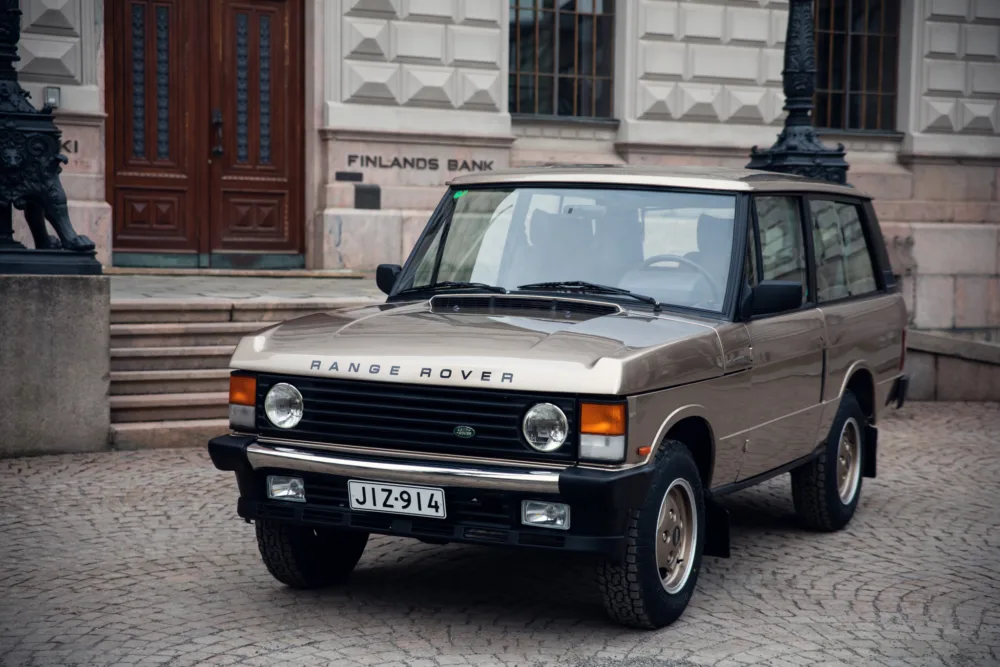 Vintage Range Rover parked in urban setting.
