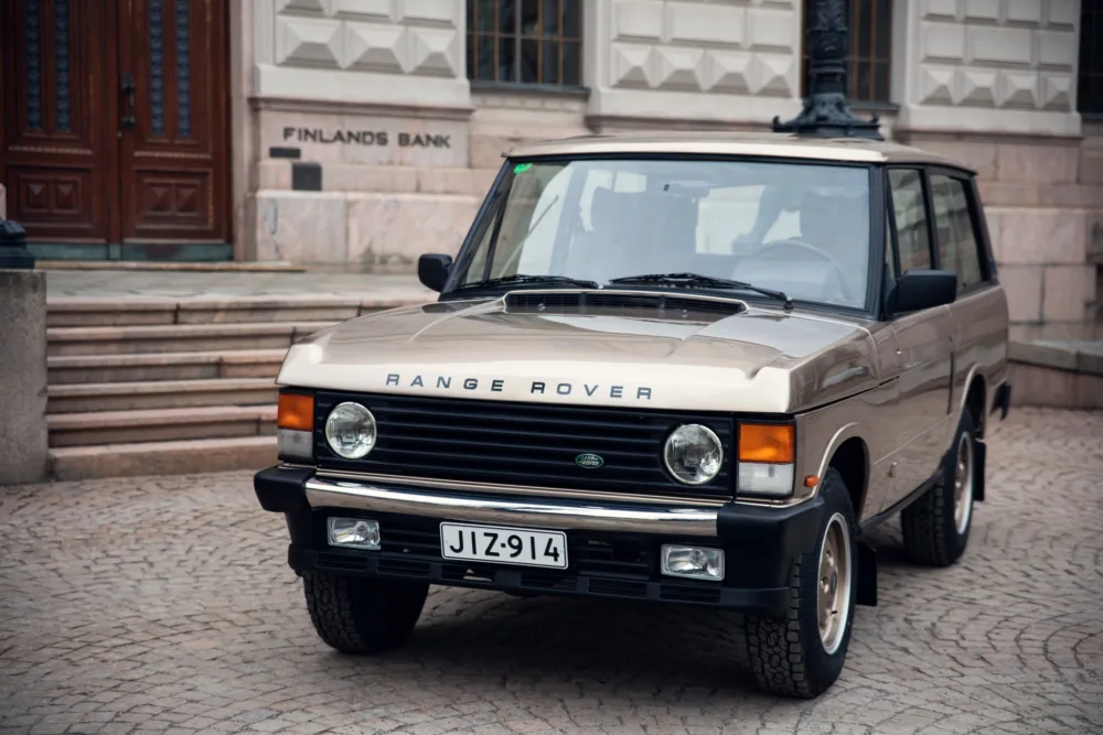 Vintage Range Rover parked by building