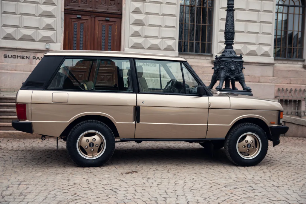 Vintage beige SUV parked near building facade.