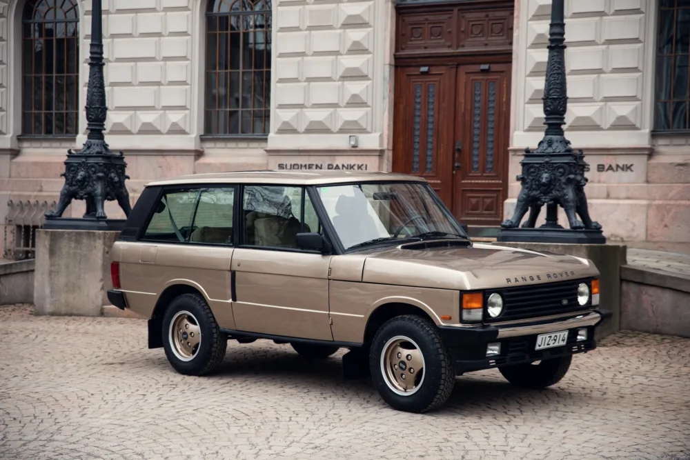 Vintage Range Rover parked in front of building.