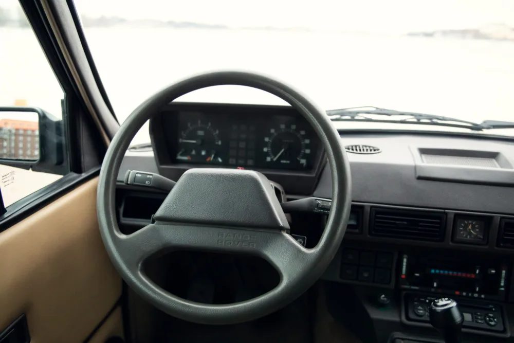 Vintage Range Rover interior with steering wheel.