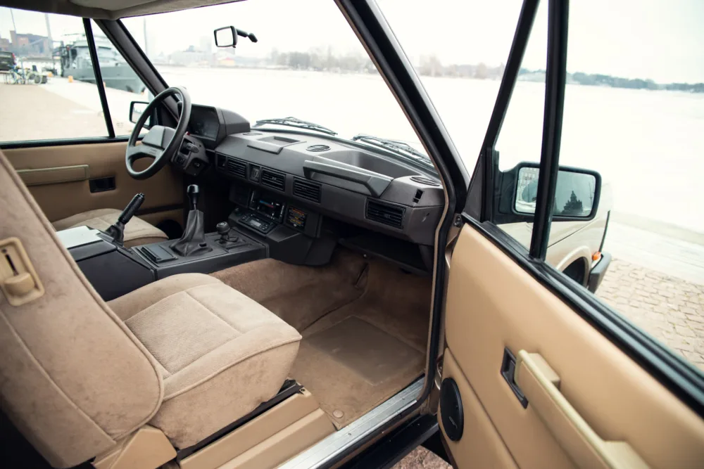 Vintage car interior, beige seats, dashboard view.