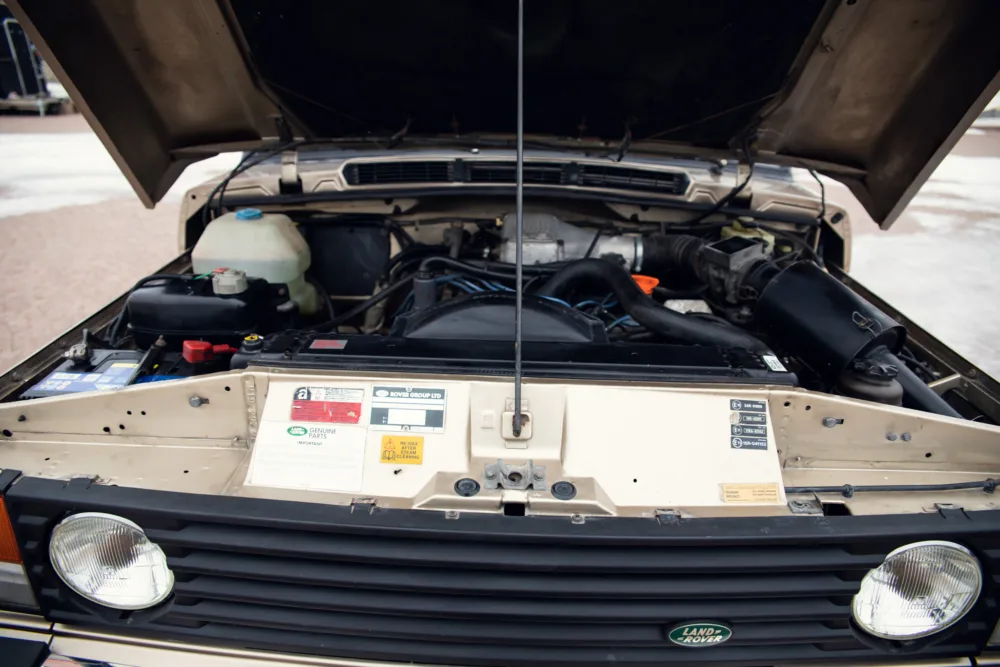 Car engine bay of an open Land Rover hood.