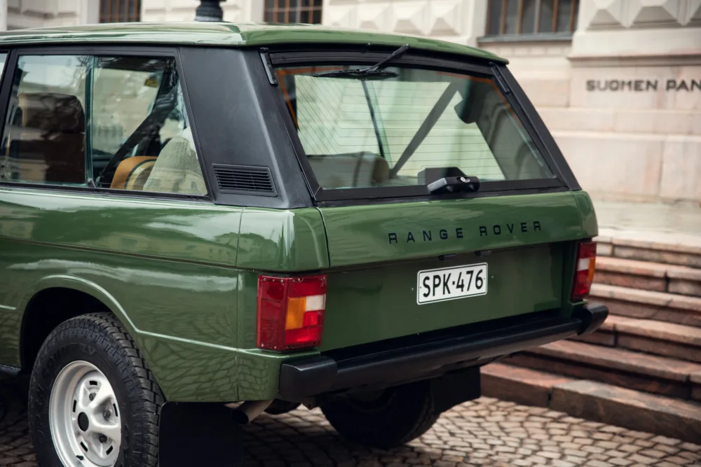 Vintage green Range Rover parked by steps