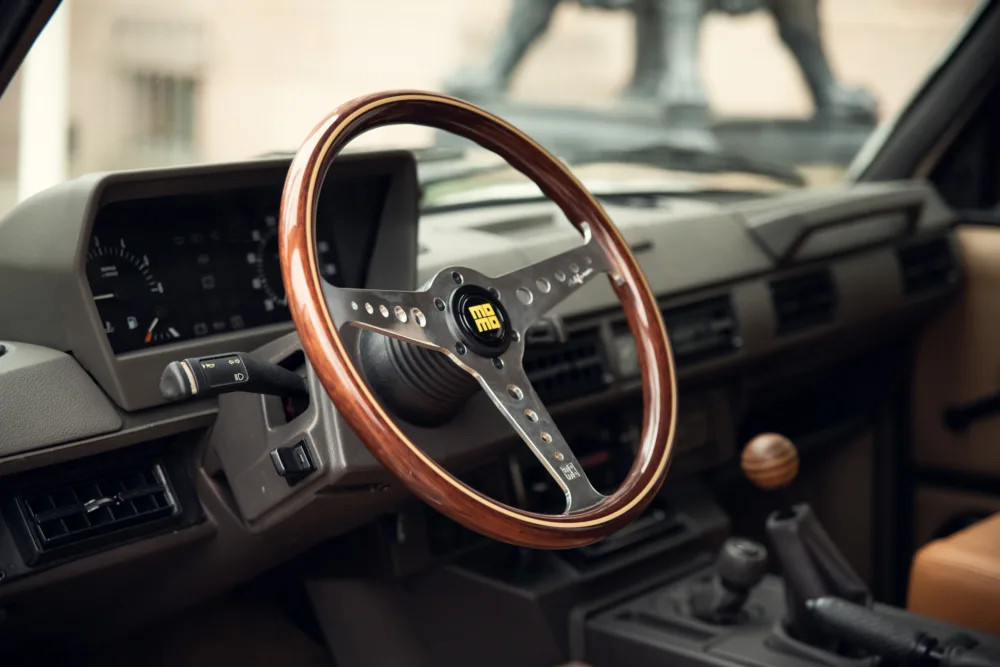 Vintage car interior with wooden steering wheel.