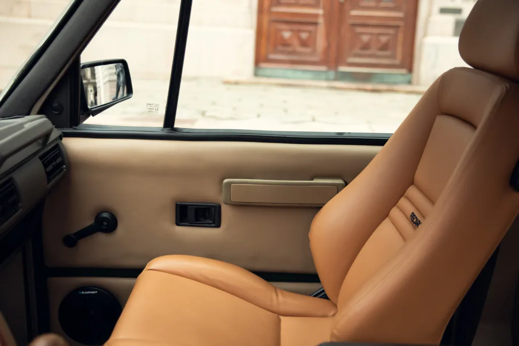 Vintage car interior with tan leather seats.