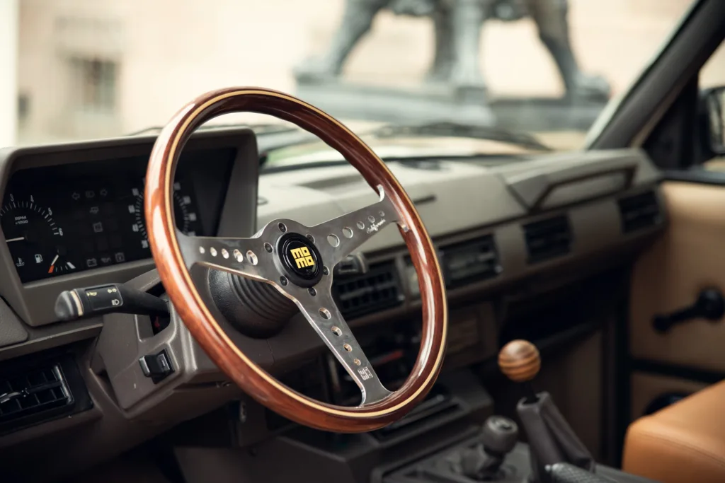 Vintage car interior with wooden steering wheel.