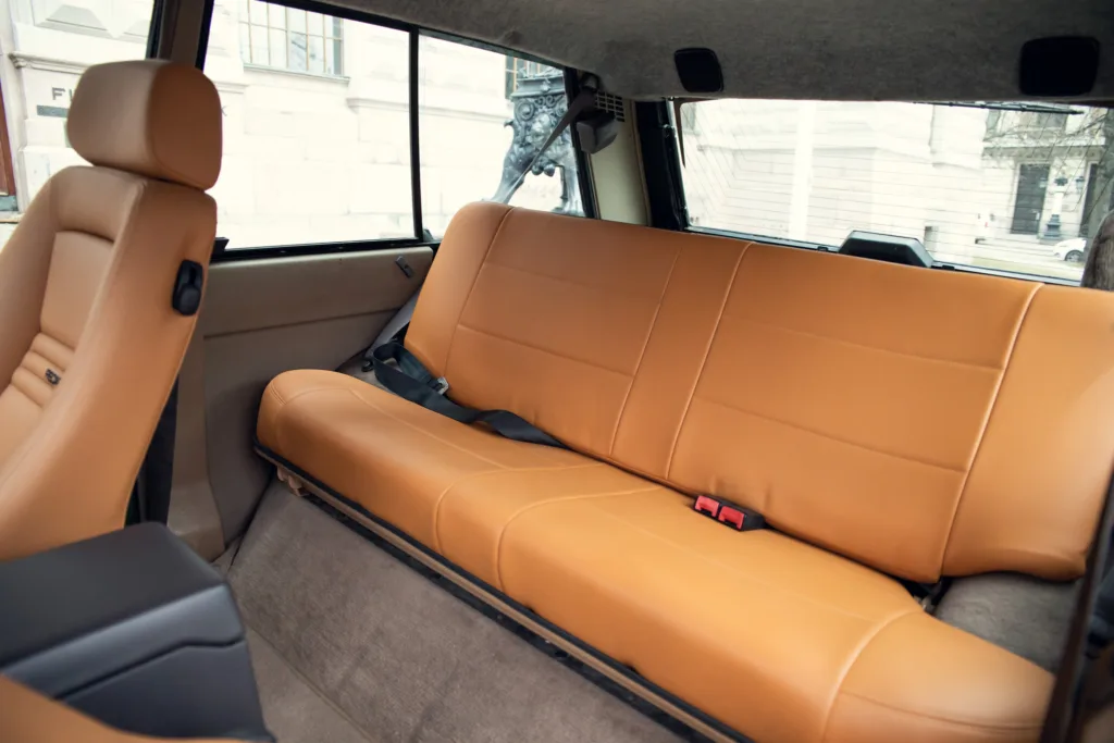 Car interior with tan leather backseat.