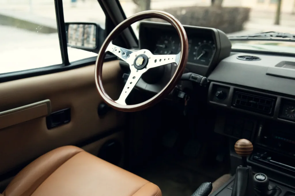 Classic car interior with wooden steering wheel.
