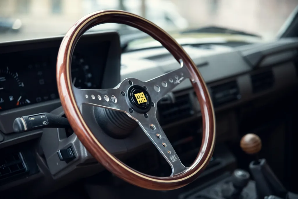 Vintage car interior with wooden steering wheel.