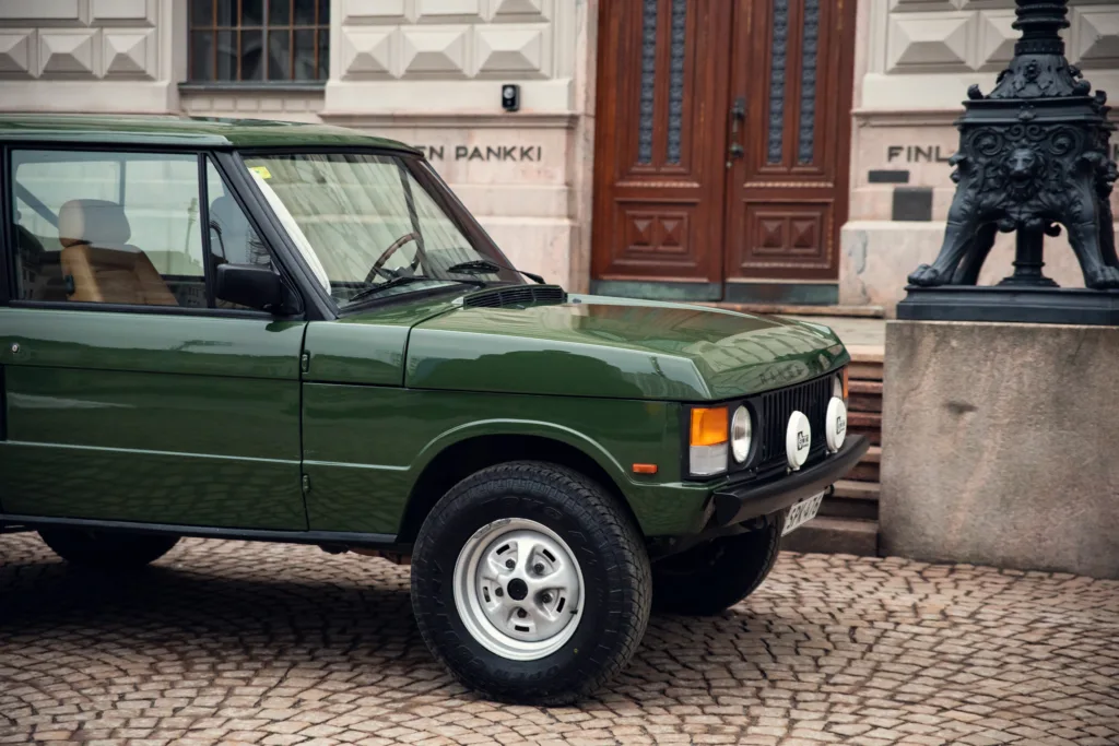 Green vintage SUV parked in urban area