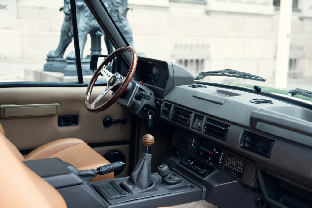 Vintage car interior with wooden steering wheel.