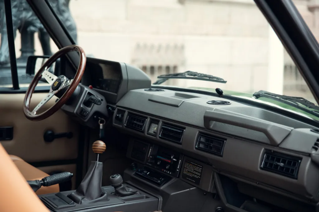 Vintage car interior with wooden steering wheel.