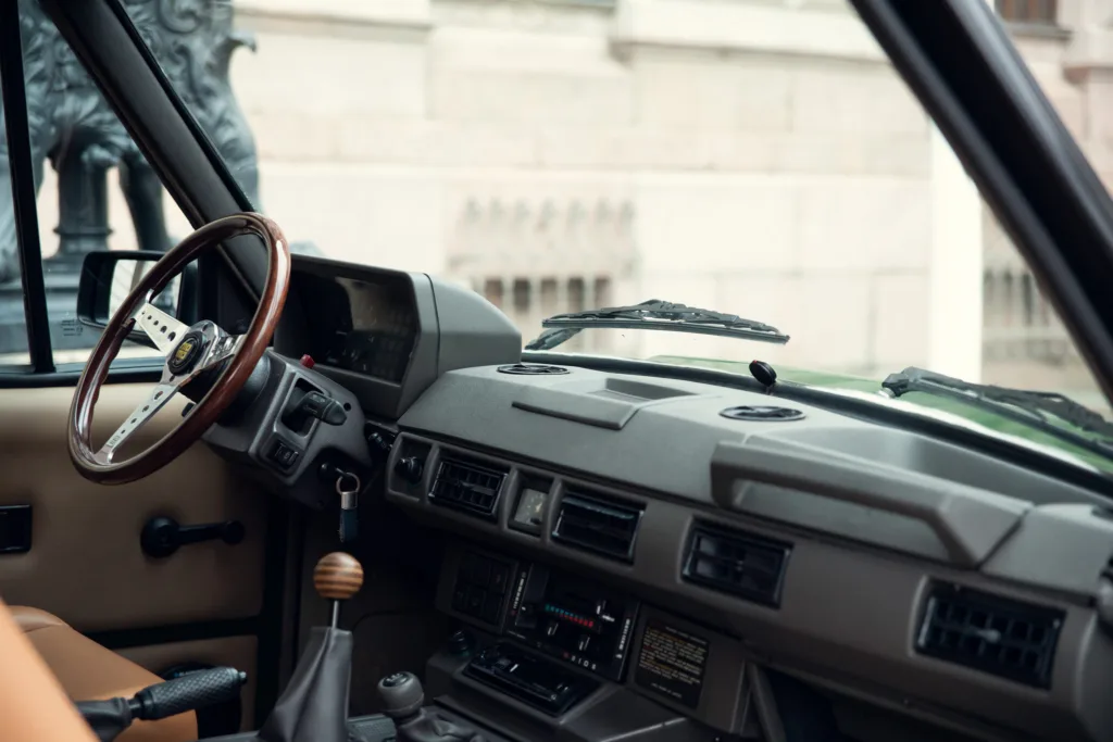 Vintage car interior with steering wheel and dashboard.