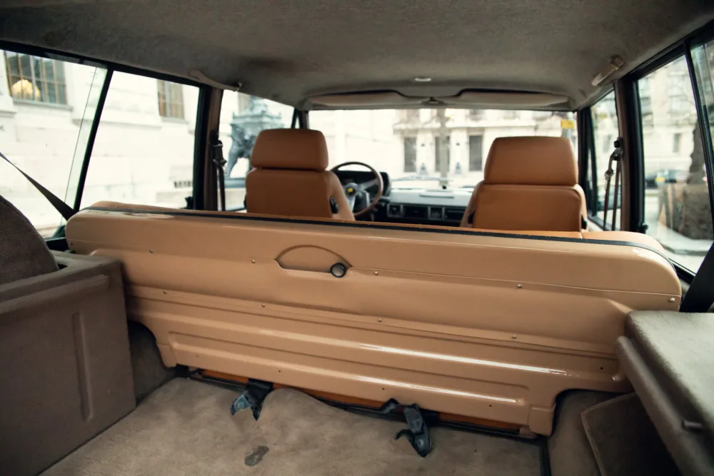 Vintage car interior with beige seats.