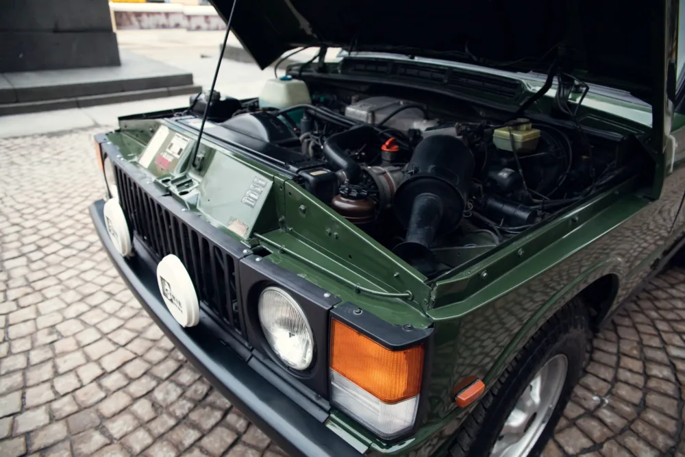 Green SUV with open hood showing engine