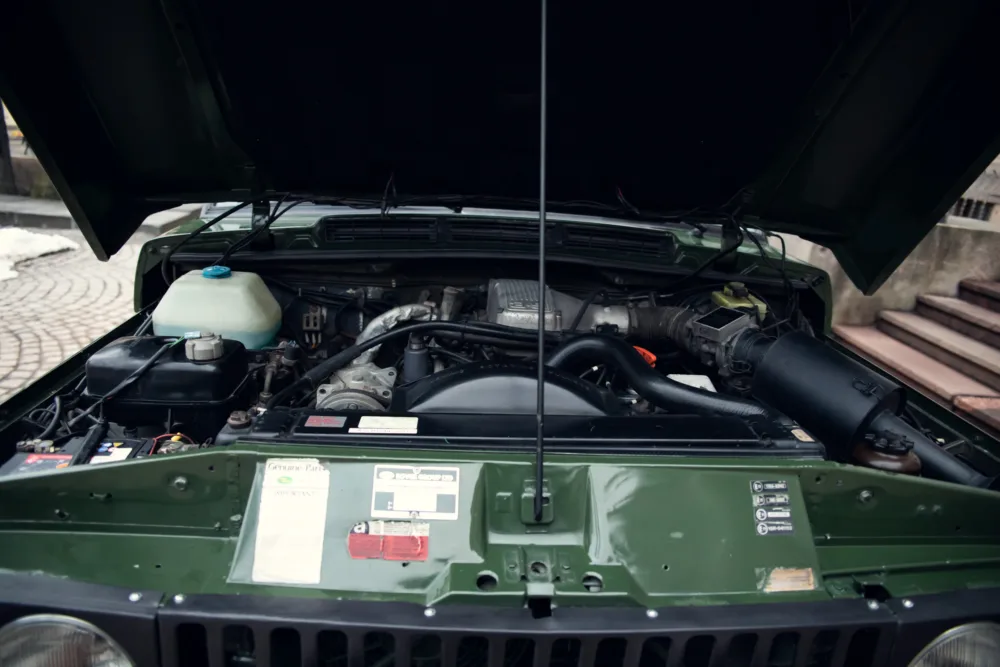 Open hood showing car engine and components.