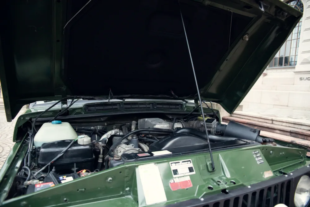 Open car hood showing engine details.