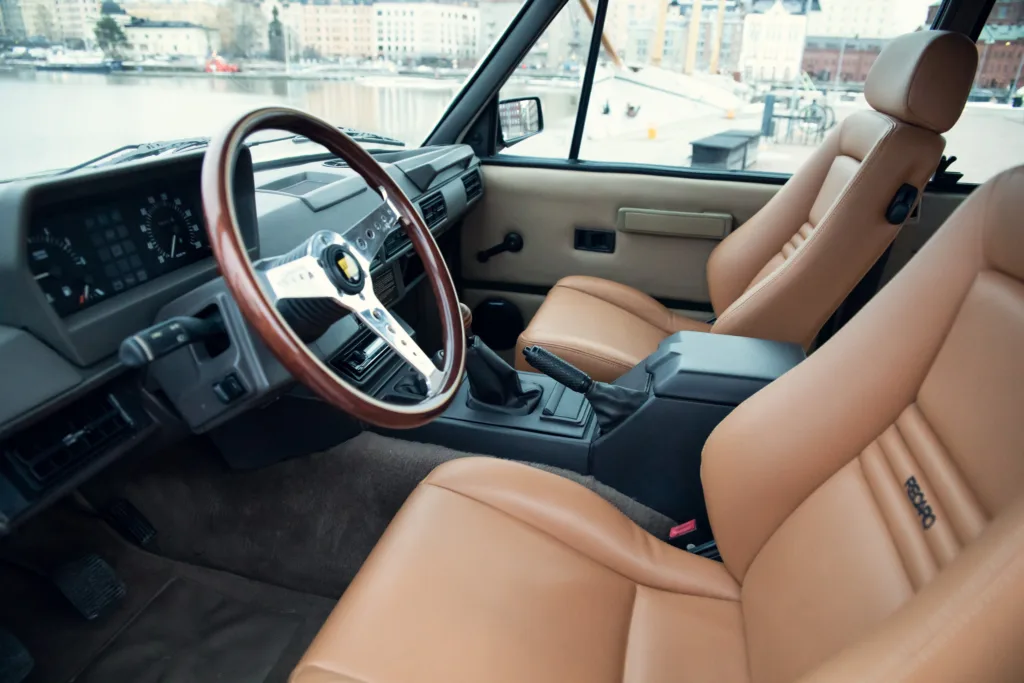 Interior of classic car with tan leather seats.