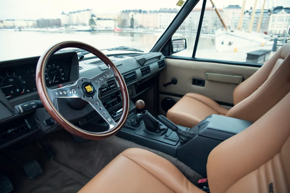 Vintage car interior with wooden steering wheel.